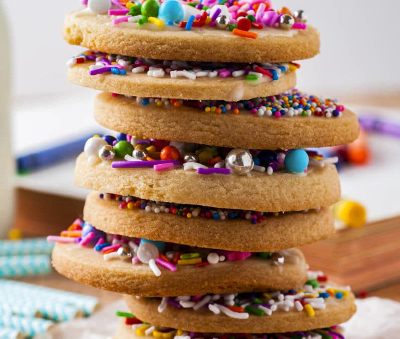 Sprinkle cookies stacked on parchment paper